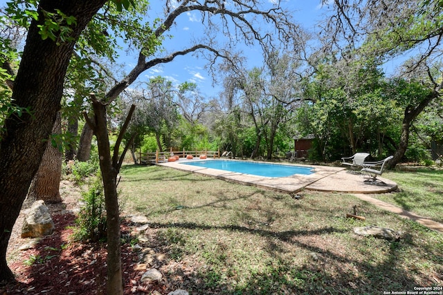 view of pool featuring a lawn and a patio