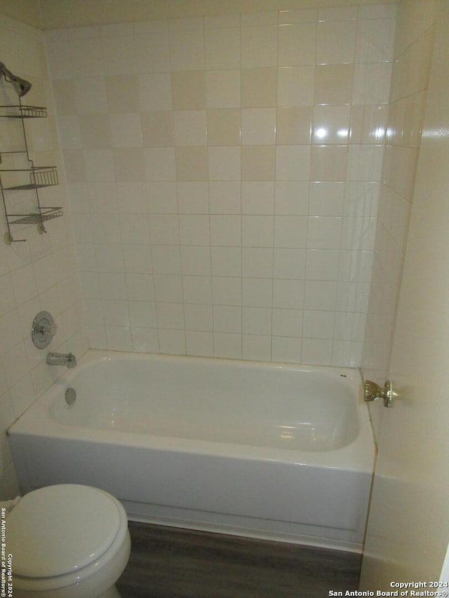 bathroom featuring tiled shower / bath and toilet