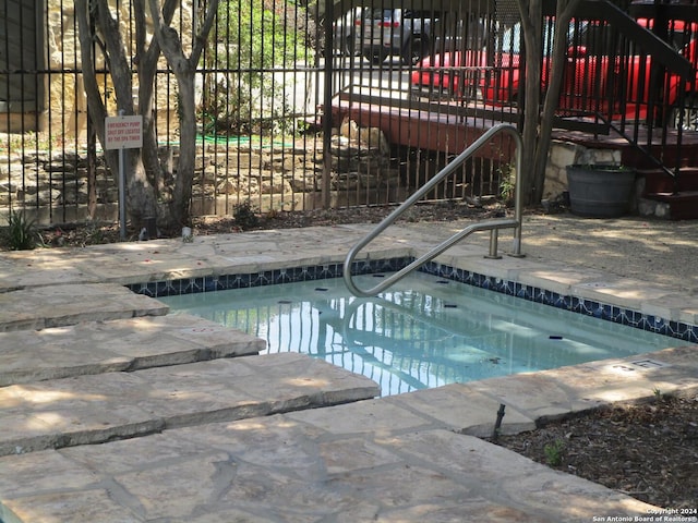 view of swimming pool featuring an in ground hot tub