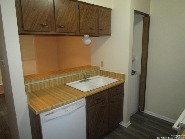 kitchen with sink, white dishwasher, and dark wood-type flooring