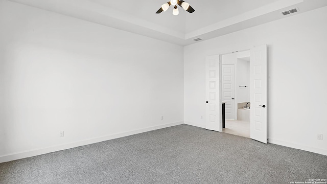 unfurnished bedroom featuring visible vents, baseboards, a raised ceiling, and ceiling fan