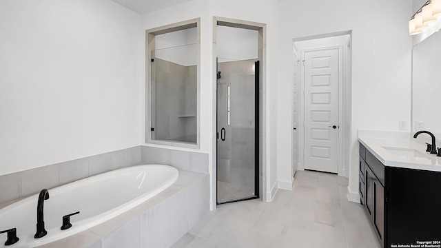 bathroom featuring a shower stall, a bath, and vanity