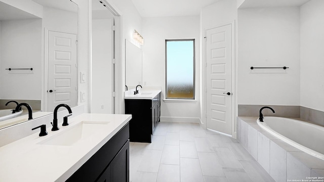 full bathroom featuring tile patterned floors, a garden tub, two vanities, and a sink