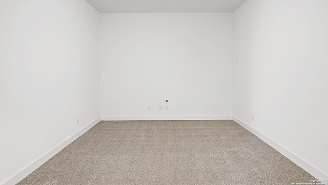 empty room with light colored carpet and baseboards