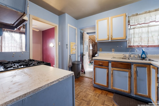 kitchen with dark parquet flooring, sink, and extractor fan