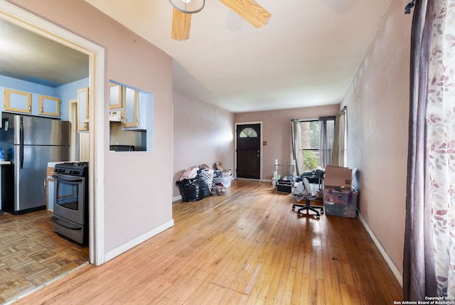 foyer entrance featuring ceiling fan and light wood-type flooring