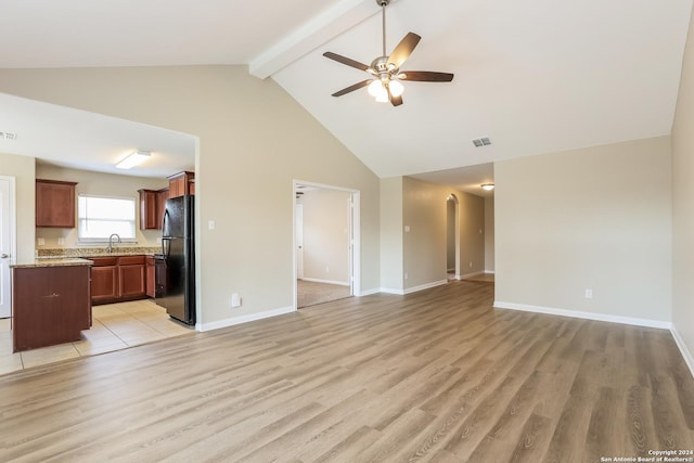 unfurnished living room featuring beamed ceiling, light wood-type flooring, high vaulted ceiling, and ceiling fan