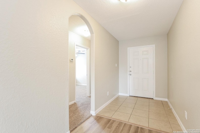 foyer with light hardwood / wood-style flooring and a textured ceiling