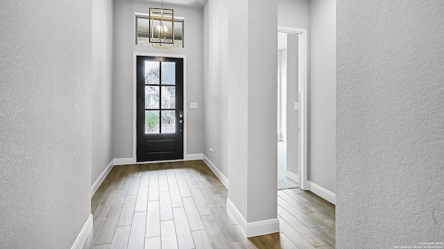 foyer entrance with a notable chandelier and hardwood / wood-style flooring