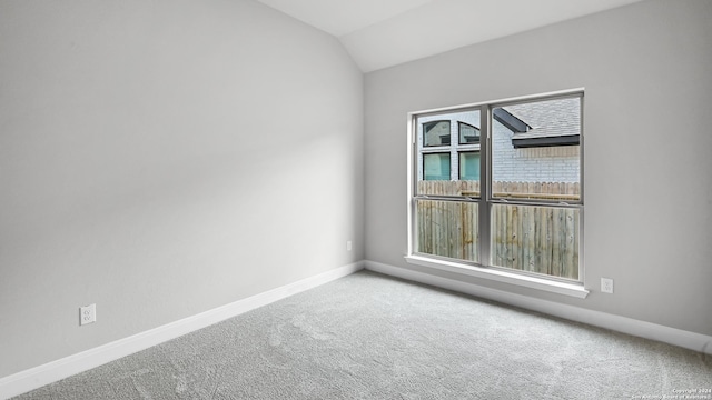 carpeted spare room with lofted ceiling