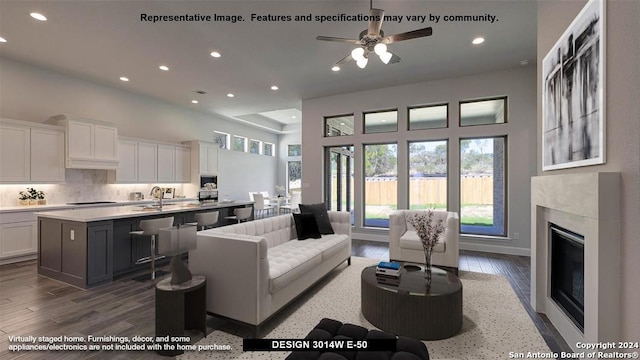 living room with a fireplace, ceiling fan, dark hardwood / wood-style flooring, and sink