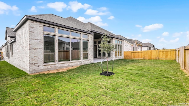 back of house with a patio area and a lawn