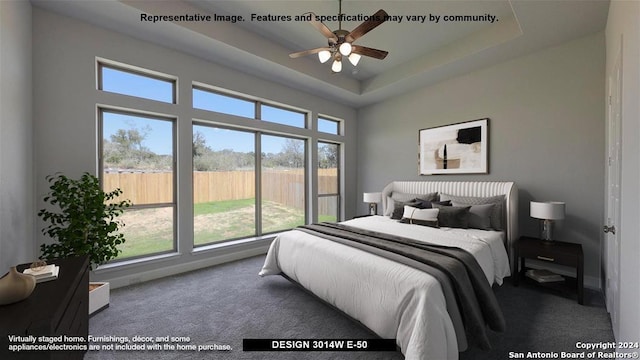 carpeted bedroom with a tray ceiling, multiple windows, and ceiling fan