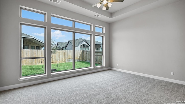 carpeted empty room featuring plenty of natural light and ceiling fan