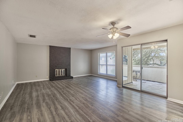 unfurnished living room with visible vents, dark wood-type flooring, a fireplace, and a textured ceiling