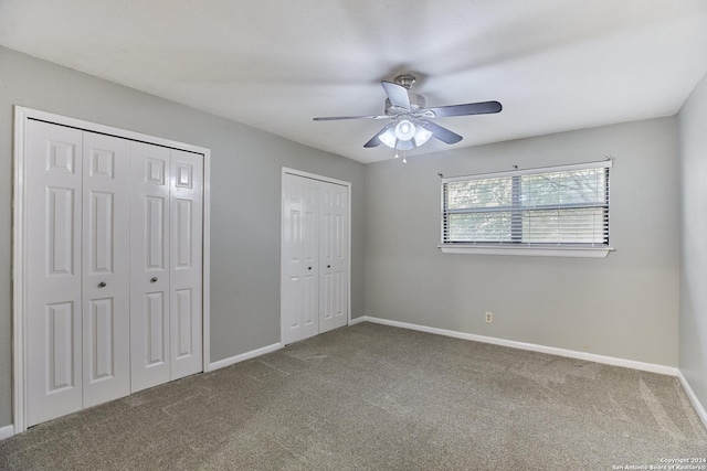 unfurnished bedroom with ceiling fan, carpet floors, and multiple closets