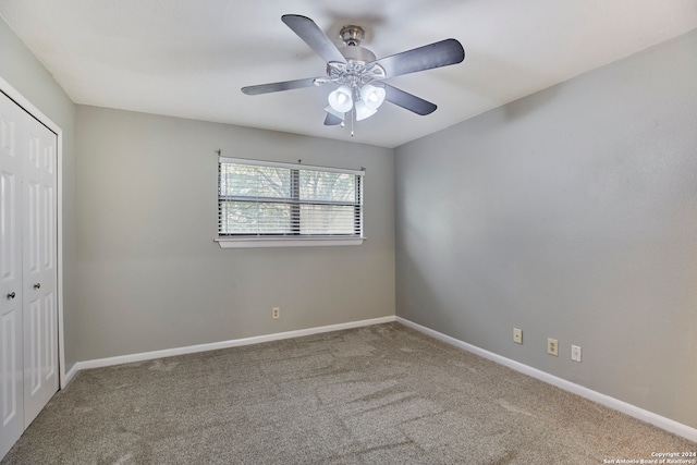 carpeted spare room with ceiling fan