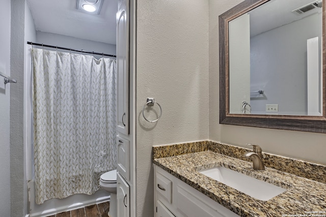 bathroom with wood-type flooring, vanity, and toilet