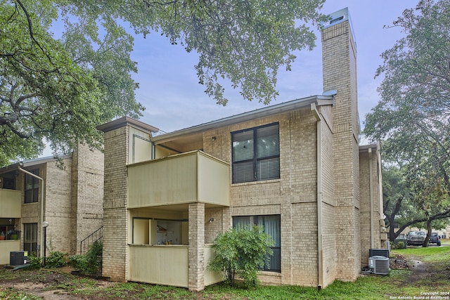 rear view of house with a balcony and central AC