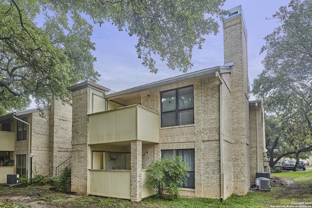 back of property with a balcony and central air condition unit