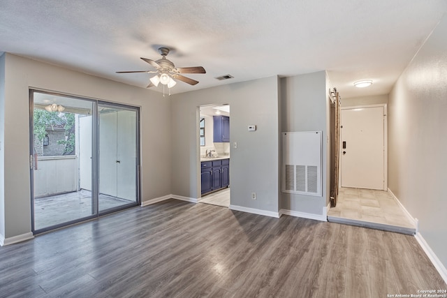 empty room featuring a textured ceiling, ceiling fan, and wood-type flooring