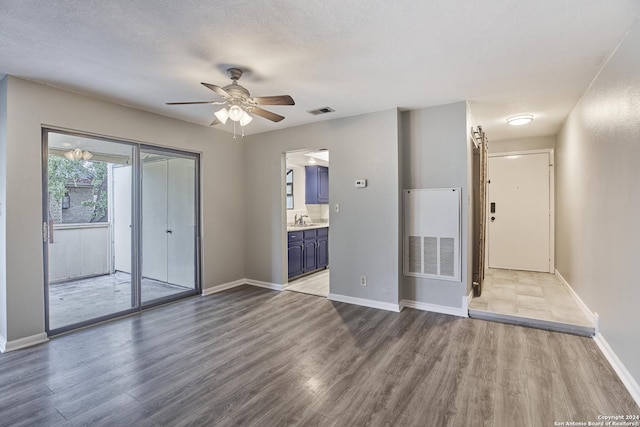 spare room featuring ceiling fan, hardwood / wood-style floors, and a textured ceiling