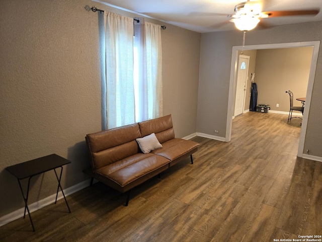 sitting room with ceiling fan, wood finished floors, and baseboards