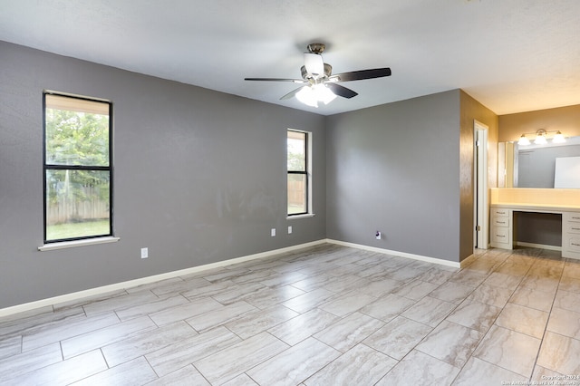 tiled spare room with a wealth of natural light and ceiling fan