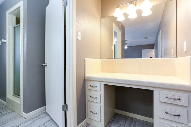 bathroom featuring ceiling fan, tasteful backsplash, tile flooring, an enclosed shower, and vanity