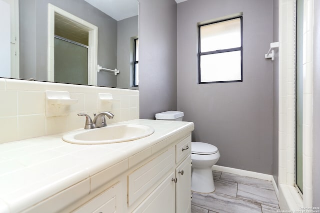 bathroom featuring toilet, tile flooring, tasteful backsplash, and oversized vanity