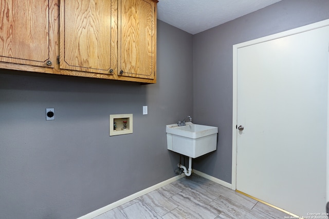 clothes washing area with cabinets, sink, washer hookup, and electric dryer hookup