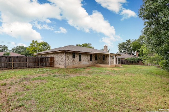 rear view of property featuring a lawn