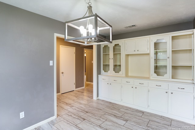 unfurnished dining area with a chandelier and light tile floors