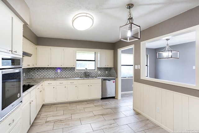 kitchen featuring appliances with stainless steel finishes, white cabinets, tasteful backsplash, and pendant lighting