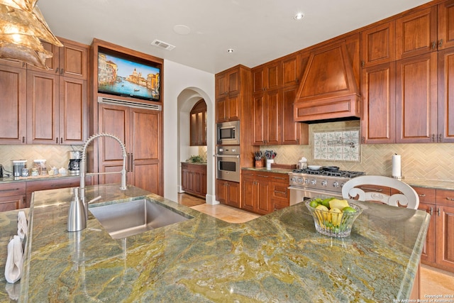 kitchen with custom exhaust hood, backsplash, sink, appliances with stainless steel finishes, and stone countertops