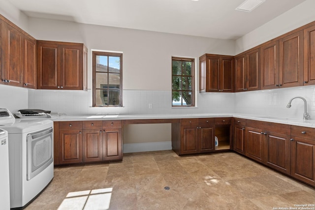 kitchen with built in desk, backsplash, washer and clothes dryer, and sink