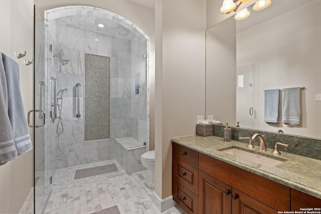 bathroom with a shower with door, vanity, and toilet