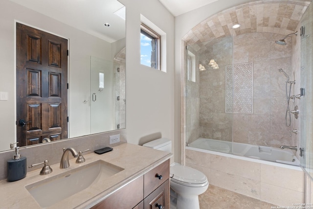 full bathroom featuring tiled shower / bath combo, toilet, and vanity