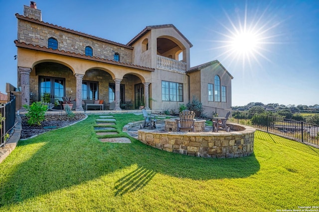 rear view of house featuring a balcony, an outdoor hangout area, a patio, and a yard