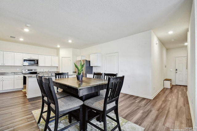 dining space with light hardwood / wood-style floors