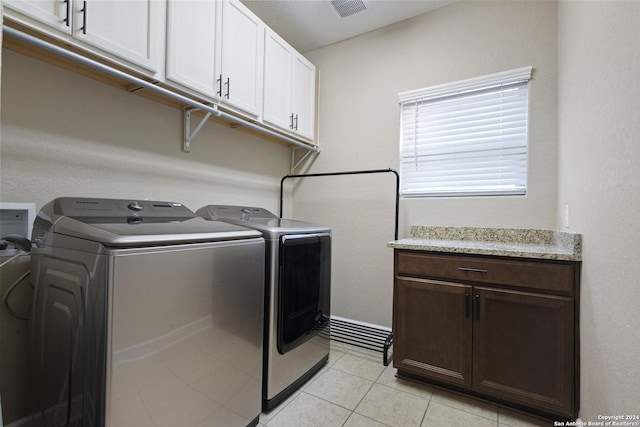 laundry room featuring cabinets, washing machine and clothes dryer, and light tile patterned floors