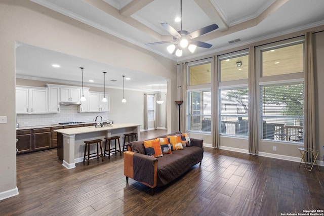 living room with ornamental molding, dark wood-type flooring, and coffered ceiling