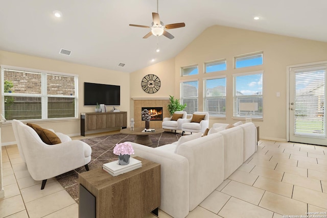 living room featuring a fireplace, light tile patterned floors, ceiling fan, and lofted ceiling