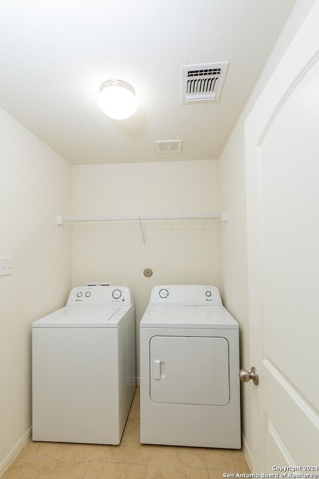 laundry room featuring washer and clothes dryer and light tile patterned flooring