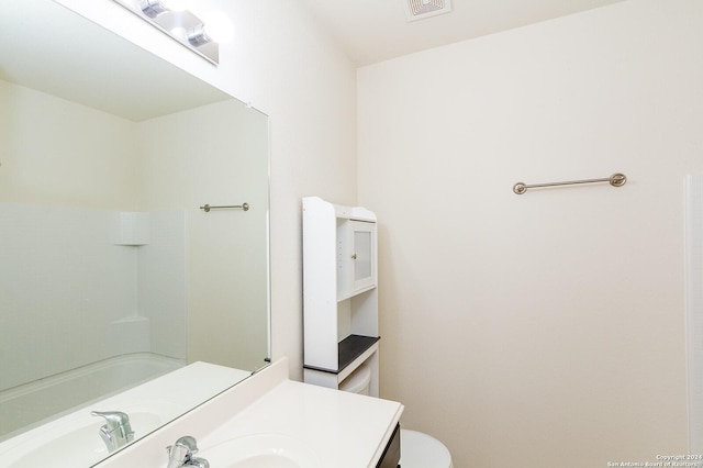 bathroom with vanity, toilet, and a shower