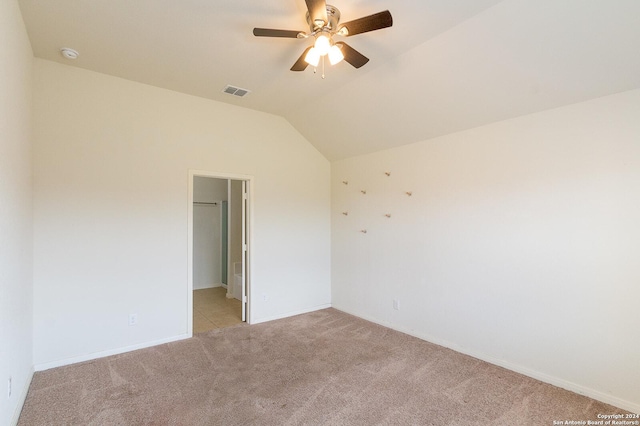 carpeted empty room featuring ceiling fan and vaulted ceiling