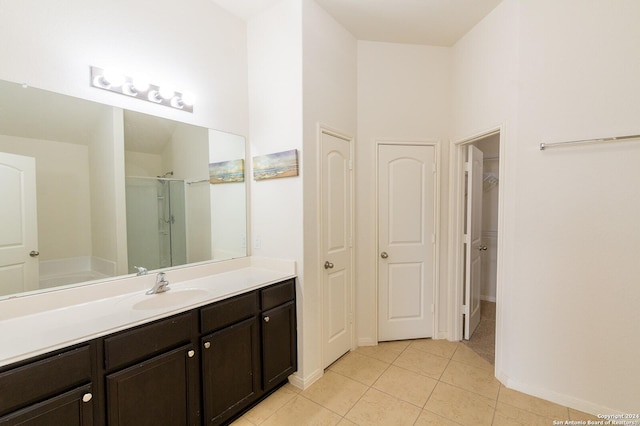 bathroom with tile patterned flooring, vanity, walk in shower, and a high ceiling