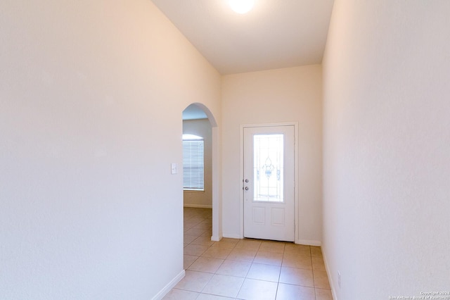 entryway with a towering ceiling and light tile patterned floors