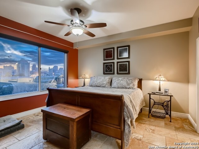 215 Center St Unit 307, San Antonio, TX 78202 - bedroom with stone tile flooring, baseboards, and a ceiling fan