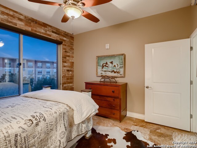 215 Center St Unit 307, San Antonio, TX 78202 - bedroom featuring brick wall, ceiling fan, and baseboards
